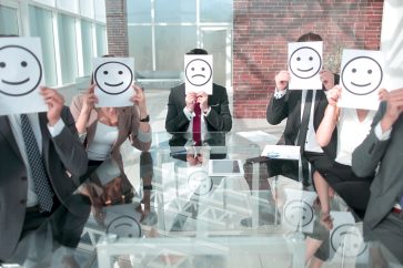 Beautiful young business team hiding behind the smiley face